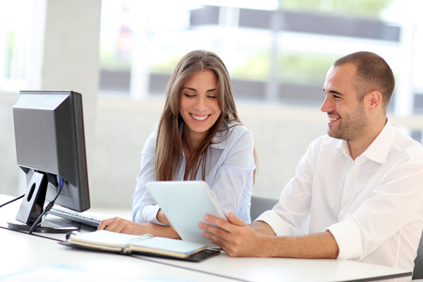 man showing woman content on tablet device